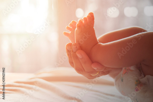 In my mother's hand there is a baby's foot. Mother who protects her child. Family warmth concept with love baby and mom photo