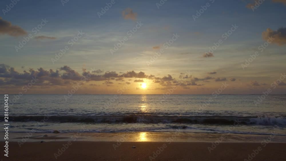 Sunset beach with small waves and beautiful blue sky ans yellow sun in Indian ocean, Bali island Sunset beach with small waves and beautiful blue sky ans yellow sun in Indian ocean, Bali island