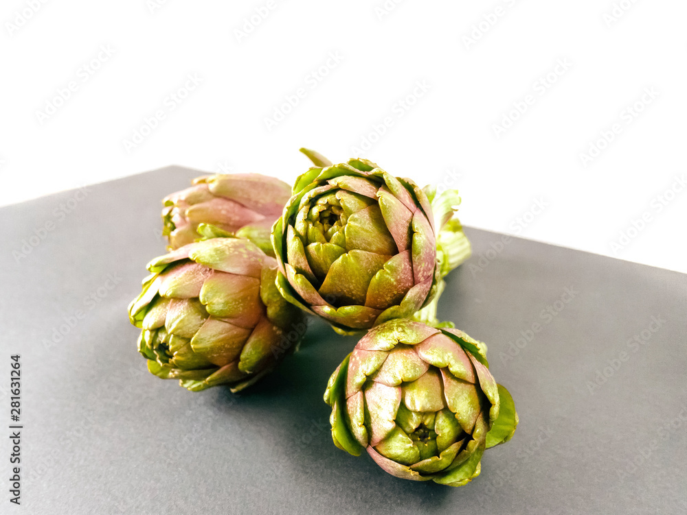 Fototapeta premium Artichokes isolated on grey and white background. Fresh organic artichoke flowers with front view