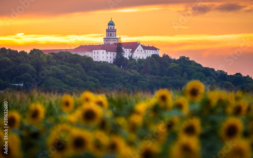 Tableau sur toile Pannonhalma Archabbey with sunflowers field at sunset time