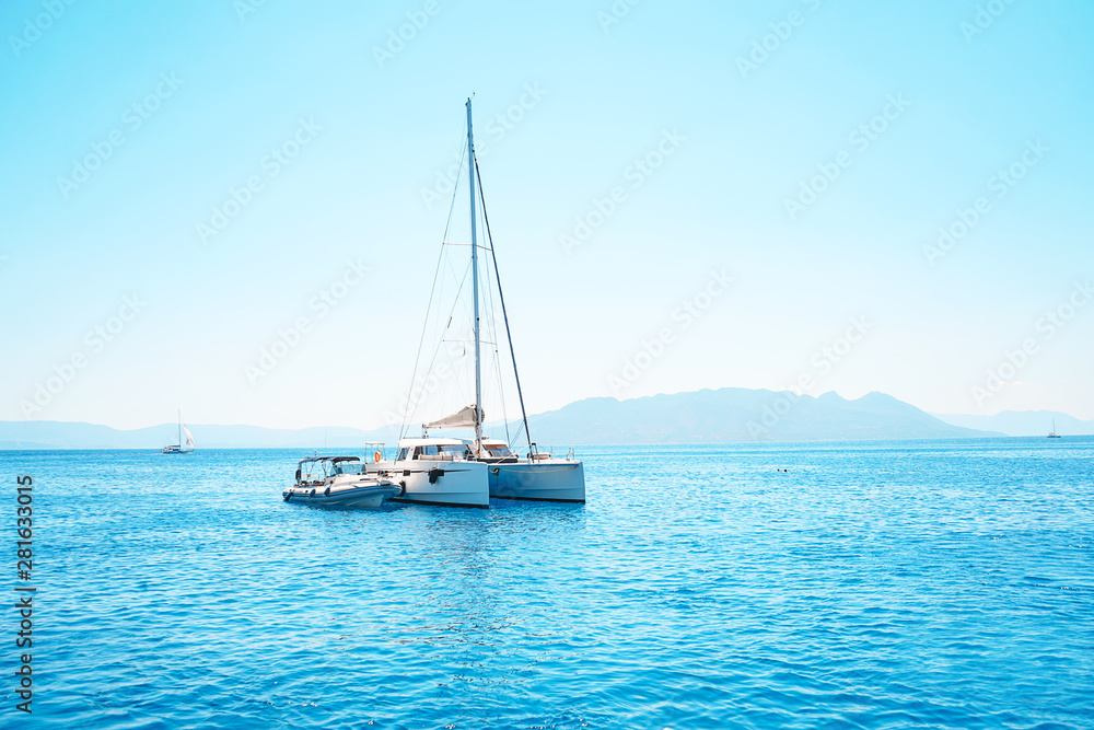 Sailing yacht catamaran in the sea in Greece, turquoise waters of Aegean Sea near Athens. Sailing yacht catamaran in the sea in Greece, turquoise waters of Aegean Sea near Athens.