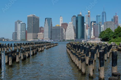 Sunny day view of East River  Pilings  Stones and Southern Manhattan Skyline with blue sky