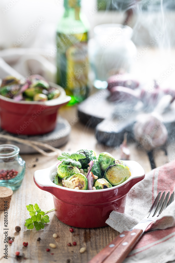 Young raw brussels sprouts in a red portion pan on a wooden background Young raw brussels sprouts in a red portion pan on a wooden background
