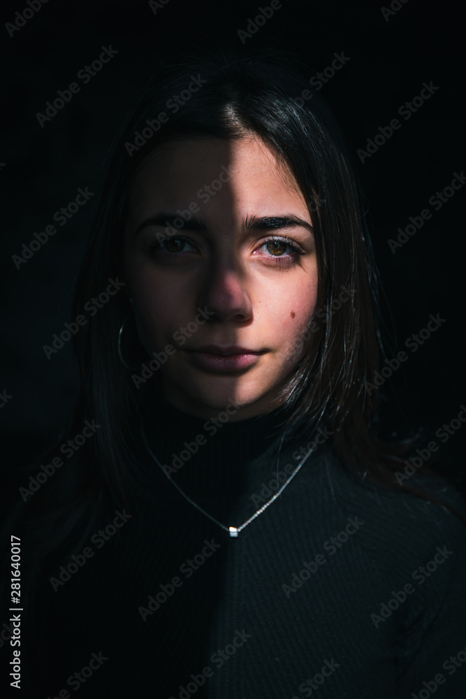 Beautiful brunette girl looking at camera, fface illuminated by the sun Beautiful brunette girl looking at camera, fface illuminated by the sun