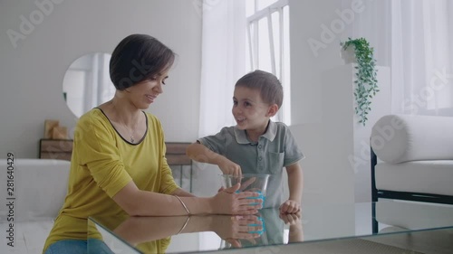 Happy and laughing mom and son play together with a Lizun, a liquid stretchable toy photo