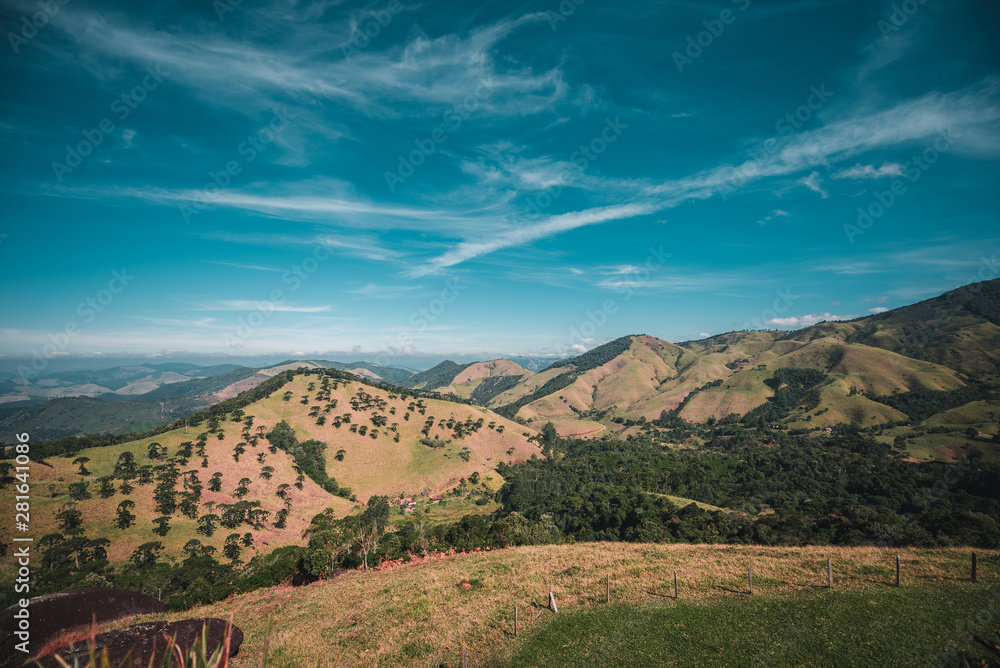 Fototapeta premium Green Hills and Mountains with Trees Under Blue Sky on Sunny Day