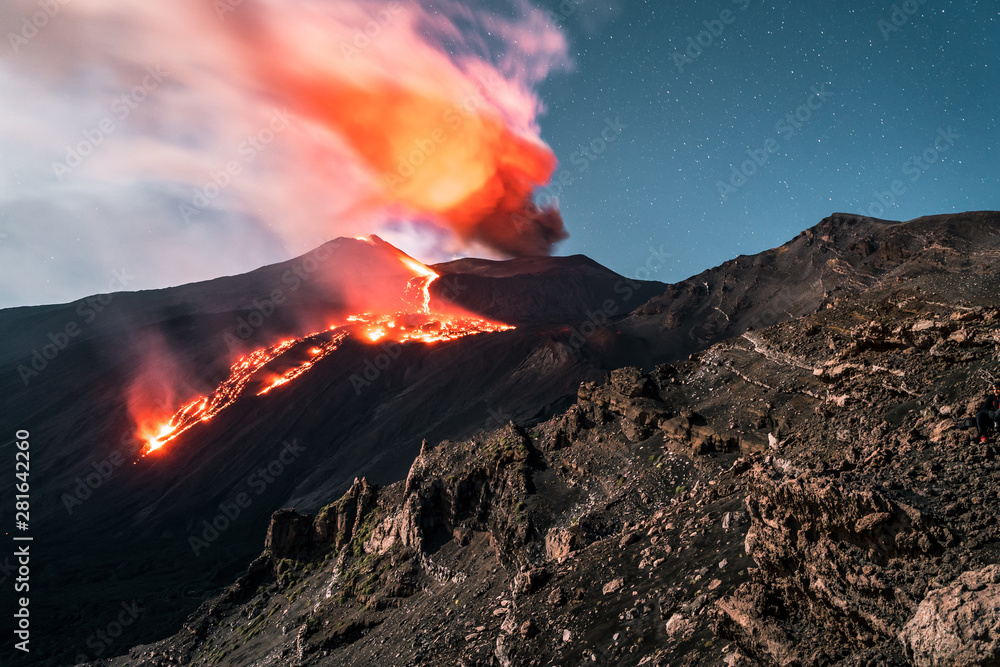 Eruption Volcano Etna with smoke and lava flow at night