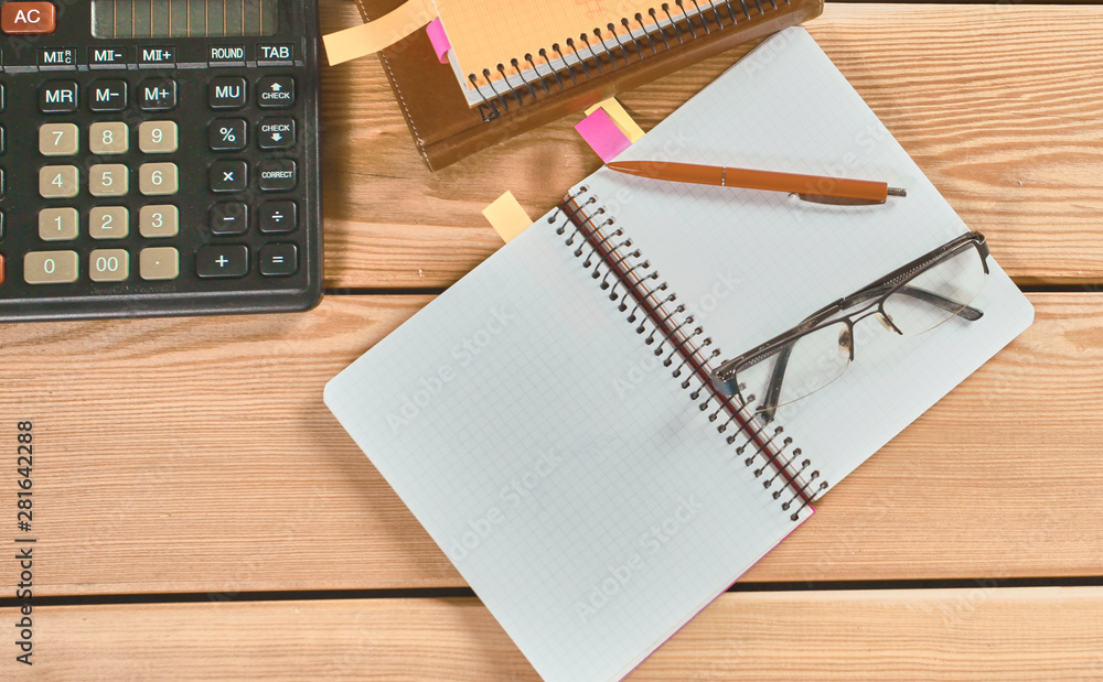 surface of a wooden table with notebook, smartphone, eye glasse surface of a wooden table with notebook, smartphone, eye glasse