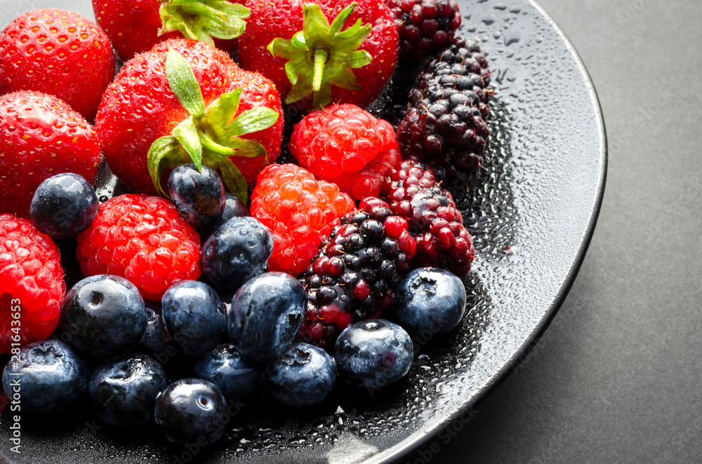 A horizontal shot of a plate of fresh summer fruit showing strawberries blue berries black berries and mulberries A horizontal shot of a plate of fresh summer fruit showing strawberries blue berries black berries and mulberries