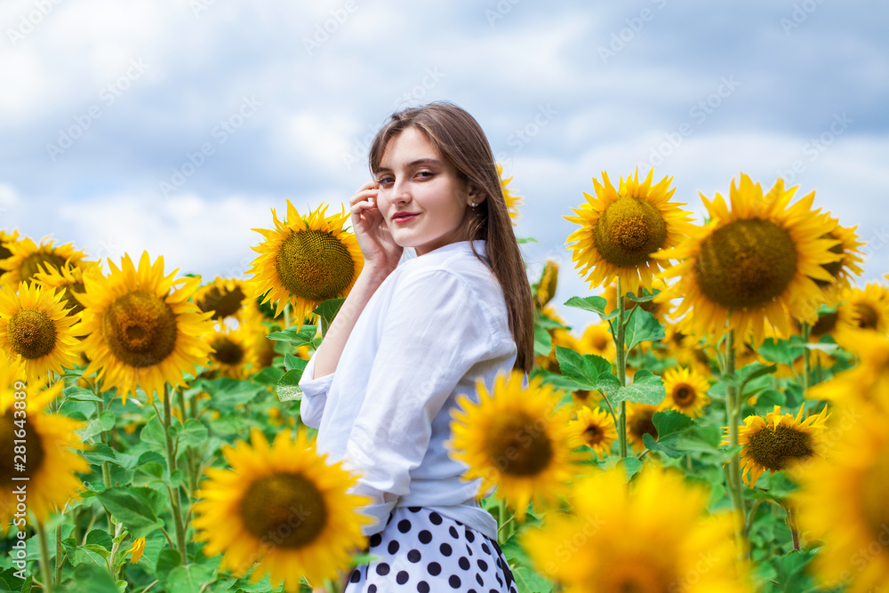 Portrait of a young beautiful girl in a field of sunflowers Portrait of a young beautiful girl in a field of sunflowers