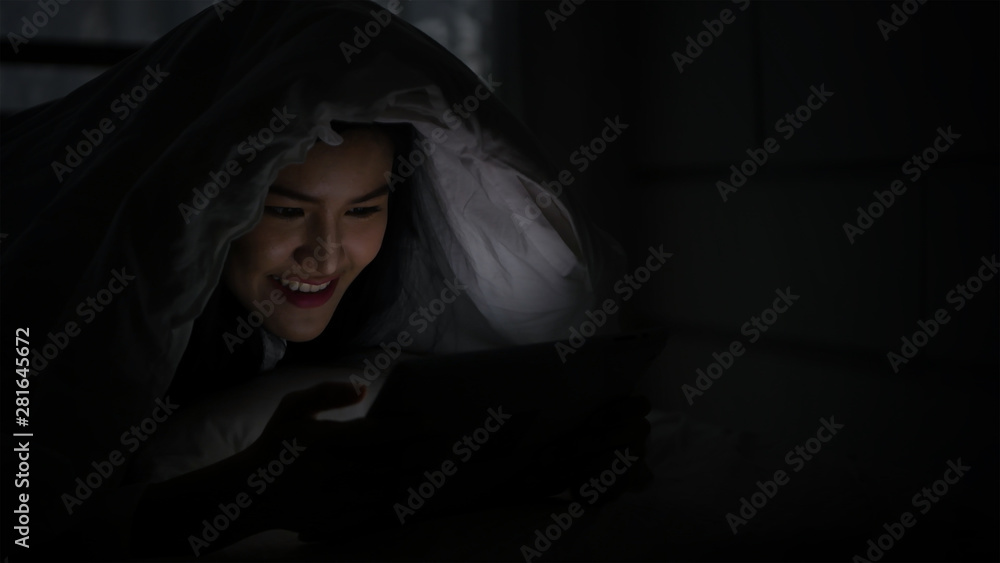 Communication concept. Women are playing tablets in the bedroom at night. Communication concept. Women are playing tablets in the bedroom at night.