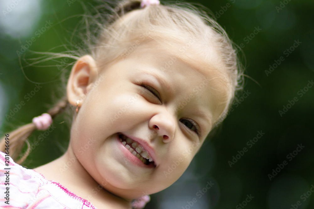Portrait of happy and smiling lttle girl giving a wink looking at camera Portrait of happy and smiling lttle girl giving a wink looking at camera