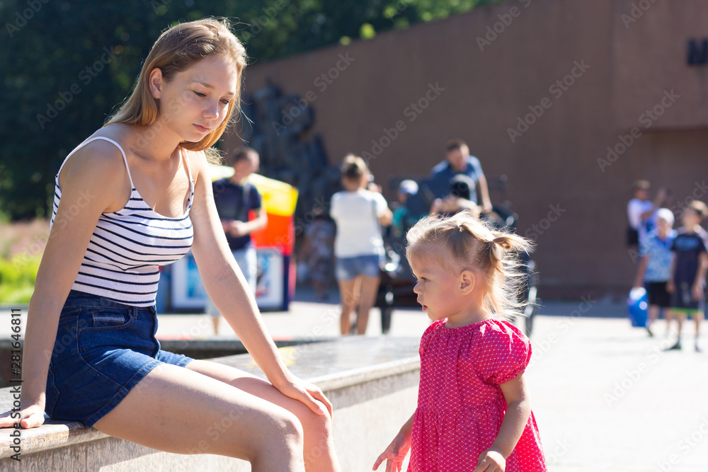 Unhappy and sad young mother with little girl outdoors