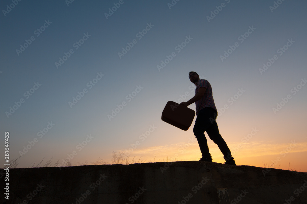 silhouette of man with suitcase at sunrise silhouette of man with suitcase at sunrise