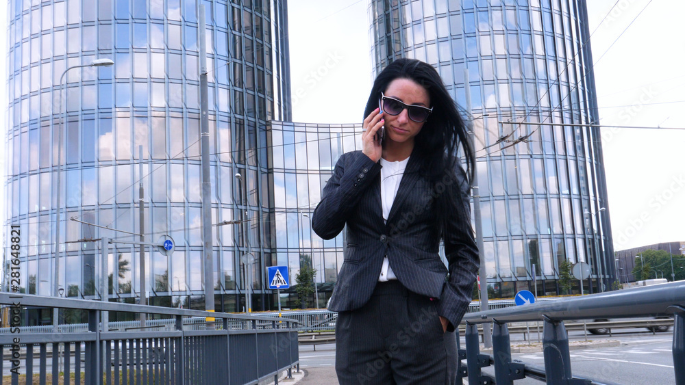 Happiness businesswoman calling by phone on the business architecture background. Concept of: Skyscraper, Business girl, Architect, Lifestyle. Happiness businesswoman calling by phone on the business architecture background. Concept of: Skyscraper, Business girl, Architect, Lifestyle.