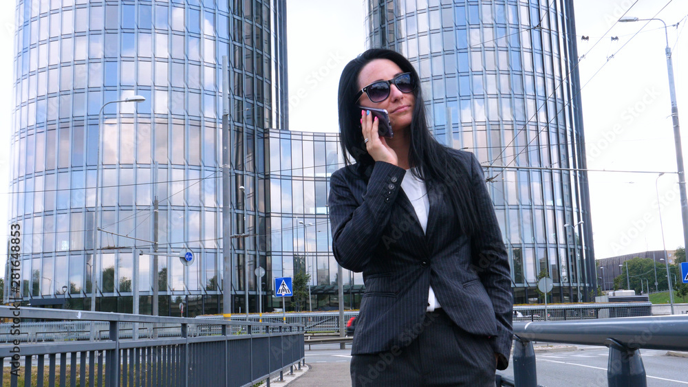 Happiness businesswoman calling by phone on the business architecture background. Concept of: Skyscraper, Business girl, Architect, Lifestyle. Happiness businesswoman calling by phone on the business architecture background. Concept of: Skyscraper, Business girl, Architect, Lifestyle.