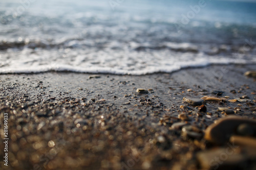 Sea waves of the blue sea with foam roll ashore the golden shore. Close-up