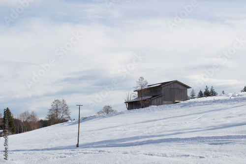 A snowy hut in winter in the Ammergau Alps near the spa town Bad Bayersoyen in Bavaria