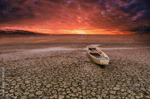 Wooden Rowboat on cracked soil in climate drought