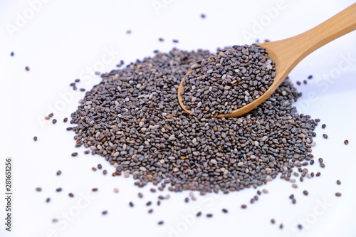 Wooden spoon full of Chia seeds on pile of Chia seeds isolate on white background.