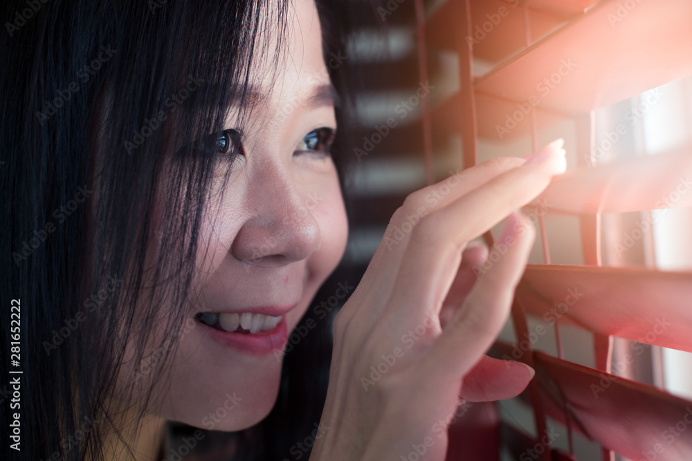 Asian woman hands apart on the window blinds Asian woman hands apart on the window blinds