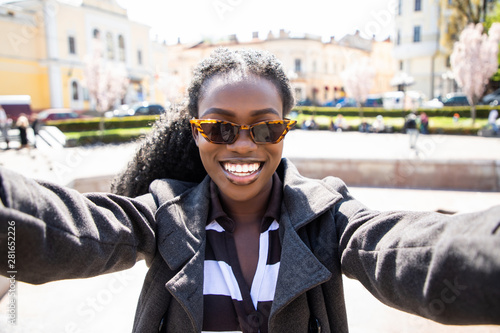 Pretty african woman taking a selfie in modern city