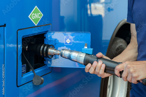 A man recharges a vehicle with compressed natural gas fuel, ecological fuel known as CNG