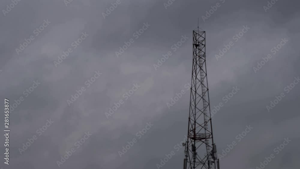 Timelapse of dramatic dark clouds with a cell phone tower in the foreground Timelapse of dramatic dark clouds with a cell phone tower in the foreground
