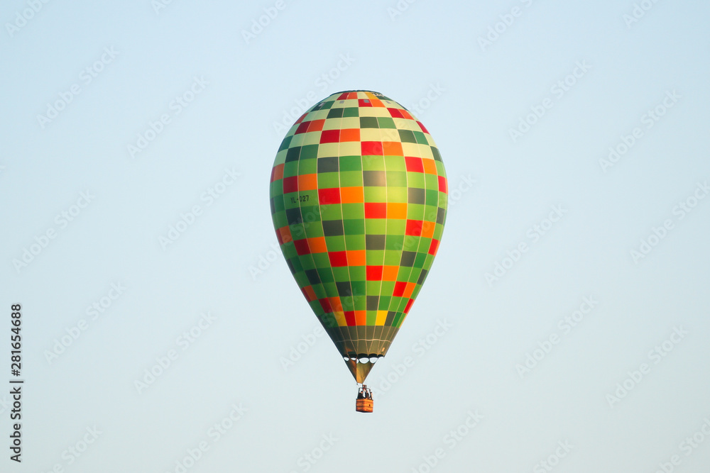Naklejka premium Beautiful view of clear sky with colorful baloon flying over a small countryside city.