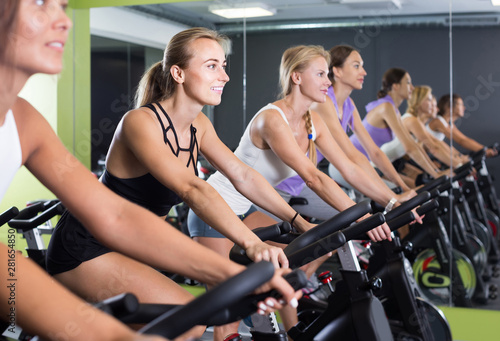 women on cardio training on exercycles in health club