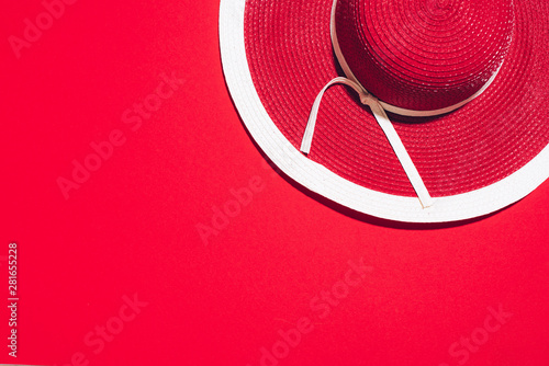 Women's summer red hat on paper background with copy space. Top view, flat lay. Summer travel and holiday concept © jchizhe