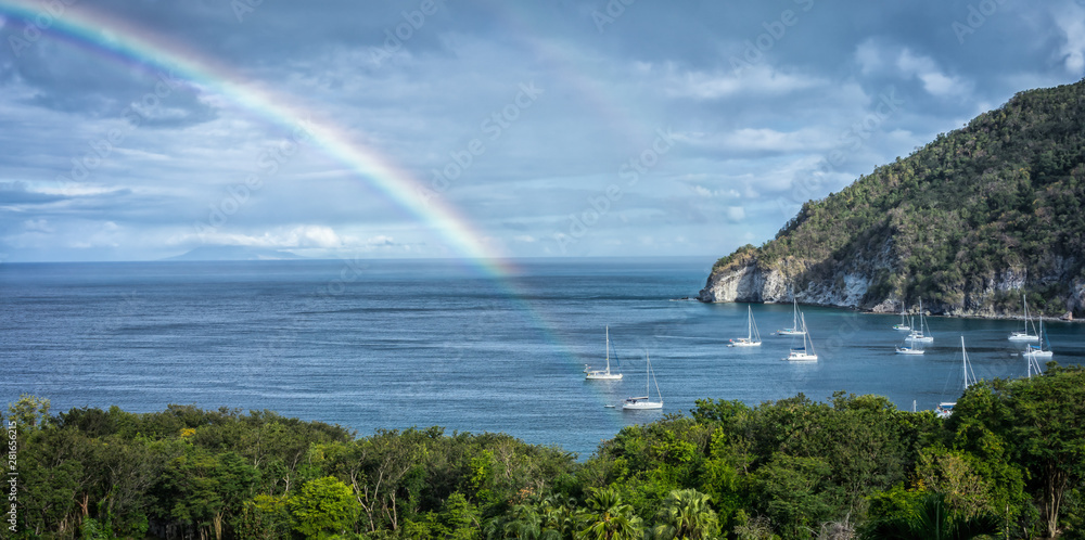 Deshaies bay in Guadeloupe with rainbow and boats