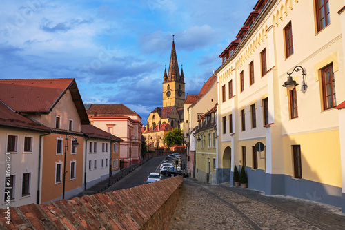 Lutheran Cathedral of Saint Mary (Catedrala Evanghelica C.A. Sfanta Maria) in the evening, with warm sunset light and cobblestone leading up to it. Symbolic, touristic spot in Sibiu, Romania. photo