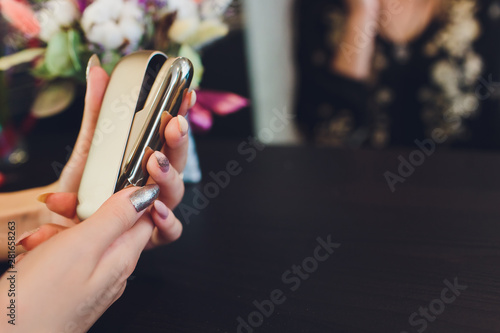 heat-not-burn tobacco product technology. woman holding e-cigarette in his hand before smoking. photo