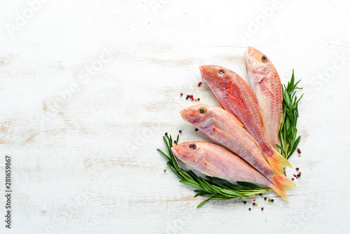 Fresh red mullet fish with lemon, salt and rosemary. Top view. Free copy space.