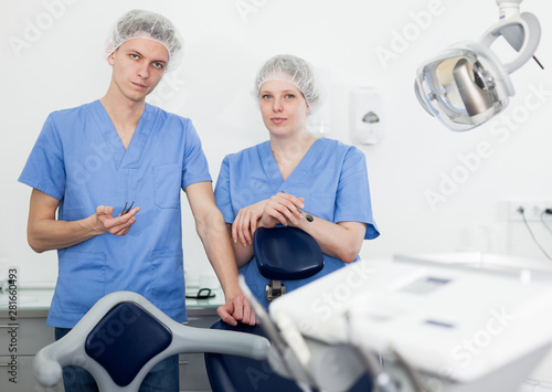 Portrait of professional dentists standing in modern medical office