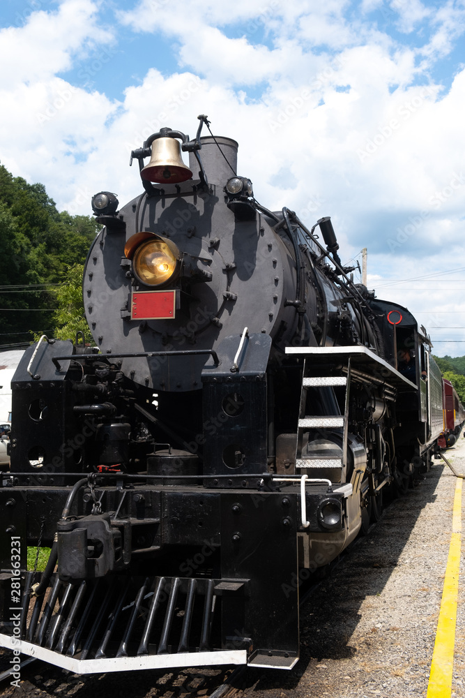 Fototapeta premium Widok z przodu lokomotywy parowej z błękitnym niebem