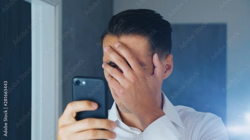 Portrait of shocked and disgusted man. Confused man saw an unpleasant message on a smartphone. He is worried about seeing. Close-up. Portrait of shocked and disgusted man. Confused man saw an unpleasant message on a smartphone. He is worried about seeing. Close-up.