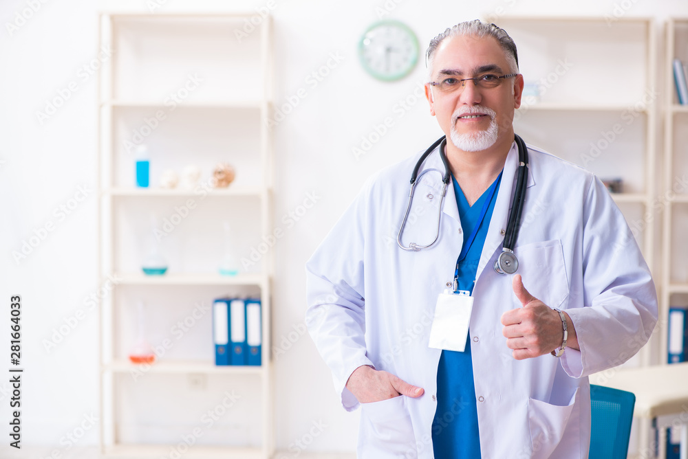 Old male doctor working in the clinic Old male doctor working in the clinic