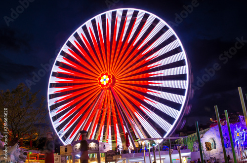 Giant Ferrieswheel with multicolour lighting during long exposure nightscape photography in an Amusement park