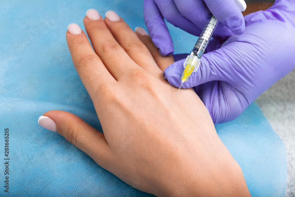 Beautician injects rejuvenation under the skin of a woman's hand  closeup. clinic of aesthetic medicine. Hand mesotherapy.