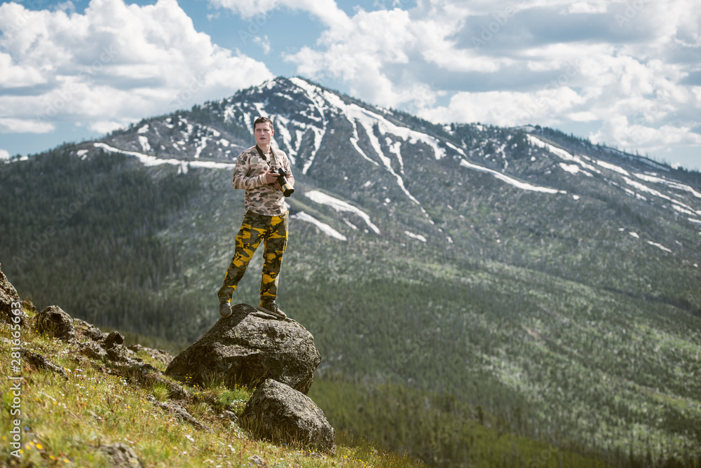Tourist man photographer taking photos and enjoy the view of mountains in Yellowstone National Park Tourist man photographer taking photos and enjoy the view of mountains in Yellowstone National Park