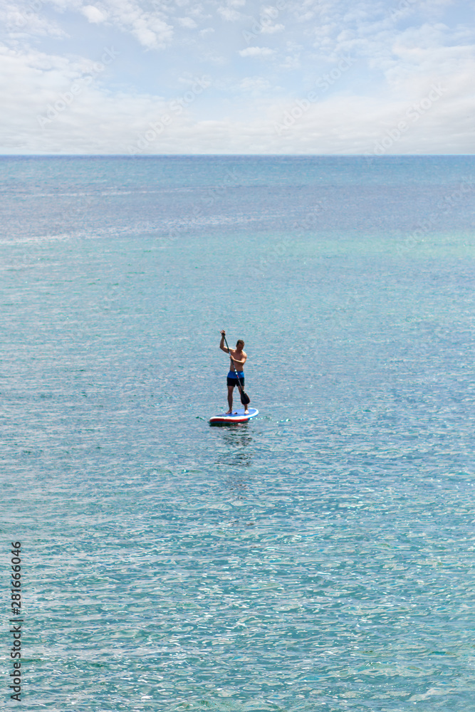Stand up paddler on the open sea on the blue turquoise water
