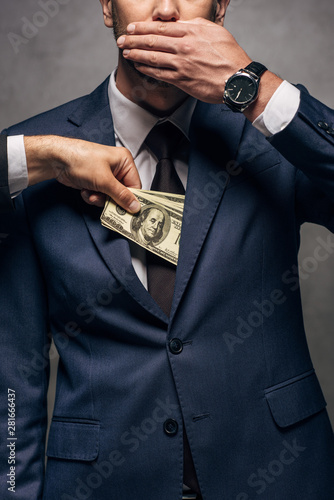 Cuadro en lienzo cropped view of man putting money in pocket of business partner covering face on