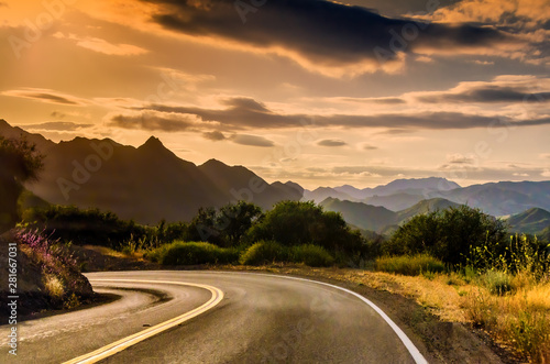 California winding highway with overcast sky, mountains background, near sunset. photo