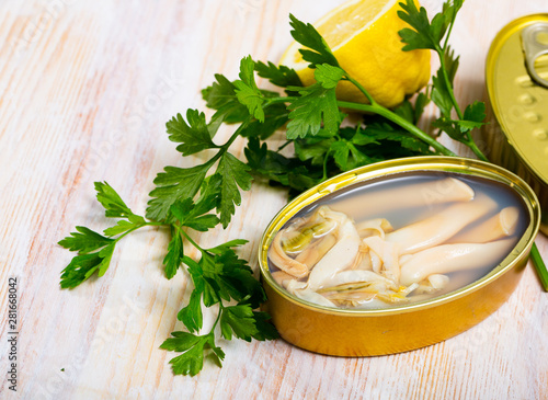 Canned natural mollusks Solen with parsley and lemon photo