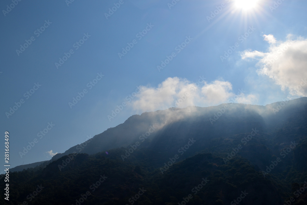 White clouds caught on a high mountain shined with the sun. Turkey