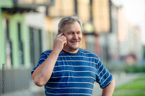  Man happily closed his eyes talking on a smartphone on the street