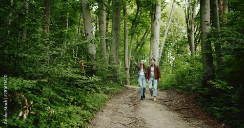 Couple of young tourists walking in mountain path and talking, active lifestyle and recreation