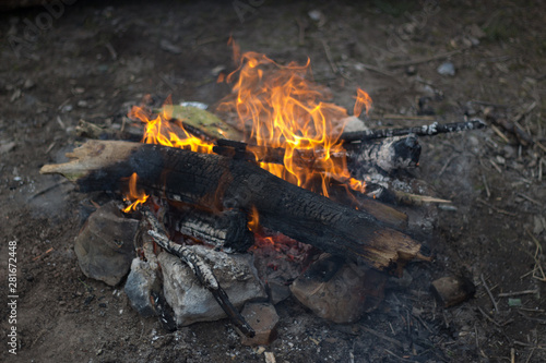 A small campfire made up of twigs and branches with rocks surrounding it